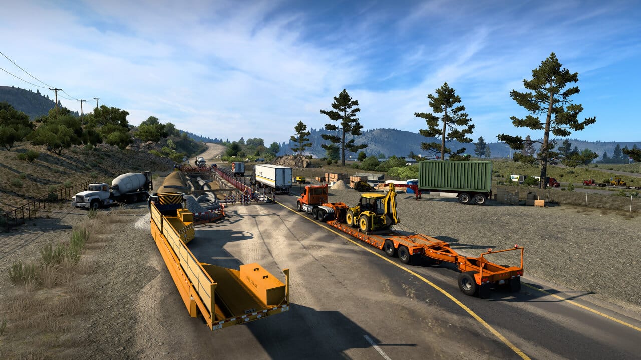 four loaded trucks are shown in this picture going down a partially open road, with two non-tractor trailers standing on the right and left sides, there's a cement mixer near the construction site too