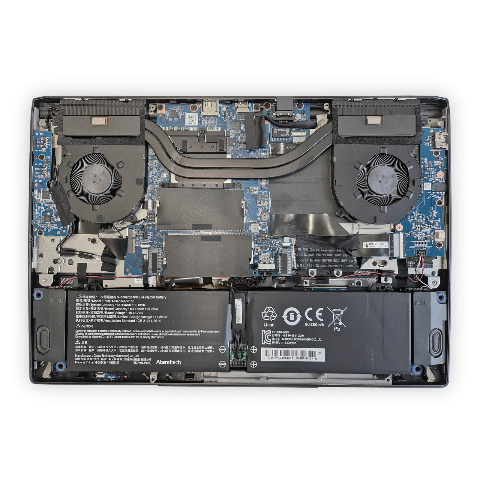 this photo shows the internals of the tuxedo infinitybook pro 15 gen 10, with the battery, two cooling fans, the blue-colored motherboard, and the removable ram sticks visible, there are a few wires running to the wireless connectivity components too