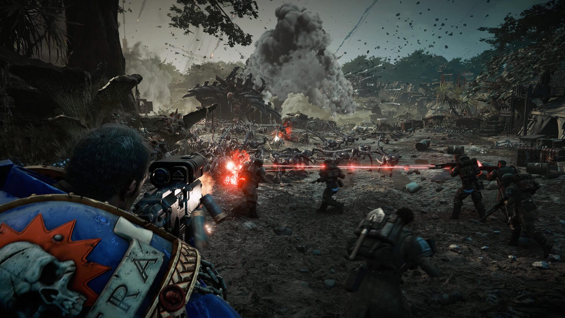 a space marine is seen firing at a horde of monsters, there are other armed npcs helping too, there's a big explosion in the background