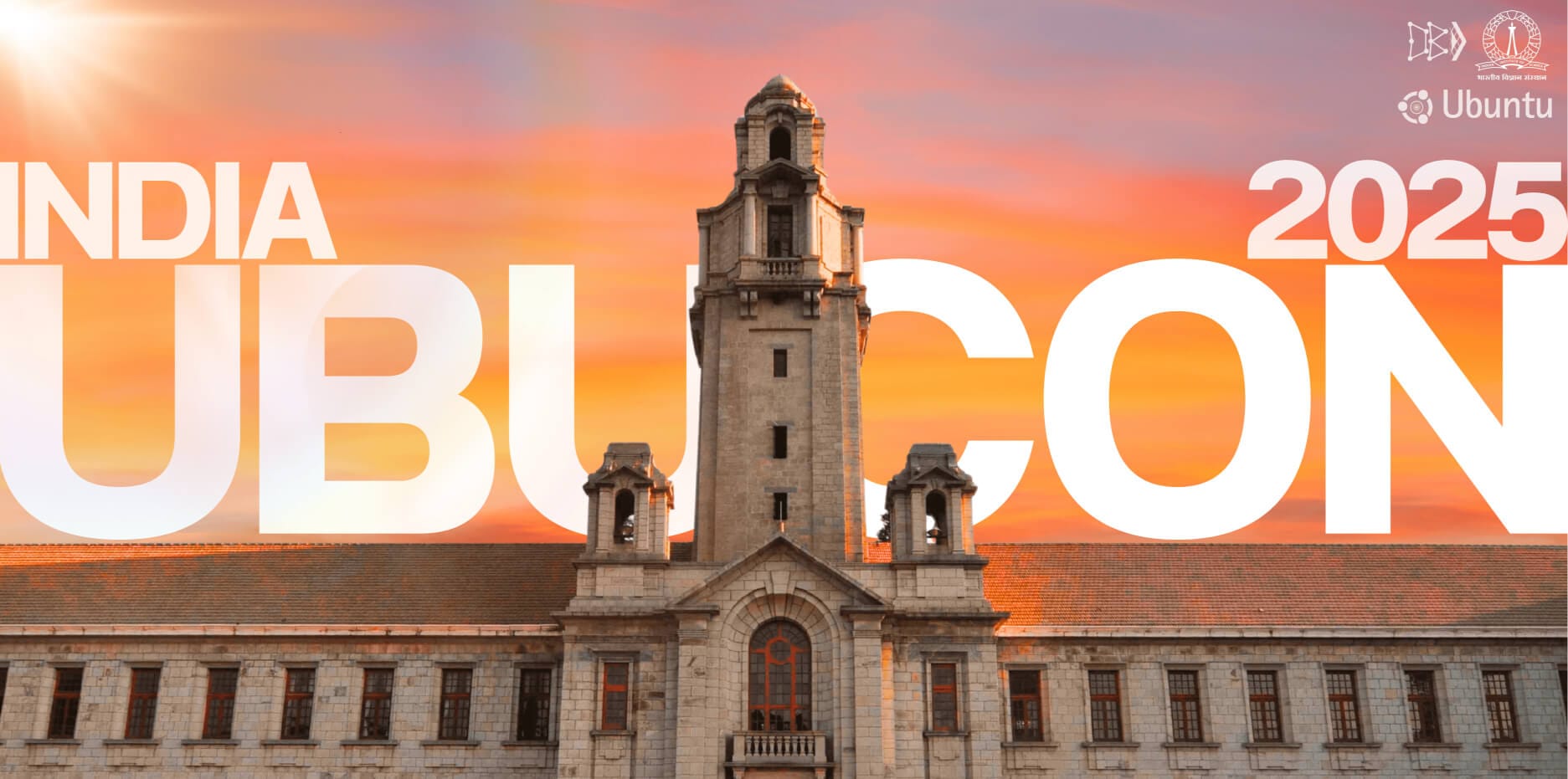 an old looking wide building with three tower-like structures is shown in the middle, with india ubucon 2025 written in the background, the logos for ubuntu india loco, indian institute of science sengaluru are shown on the top right