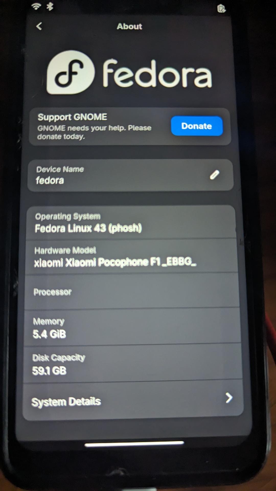 a photo that shows a poco f1 device running fedora pocketblue remix