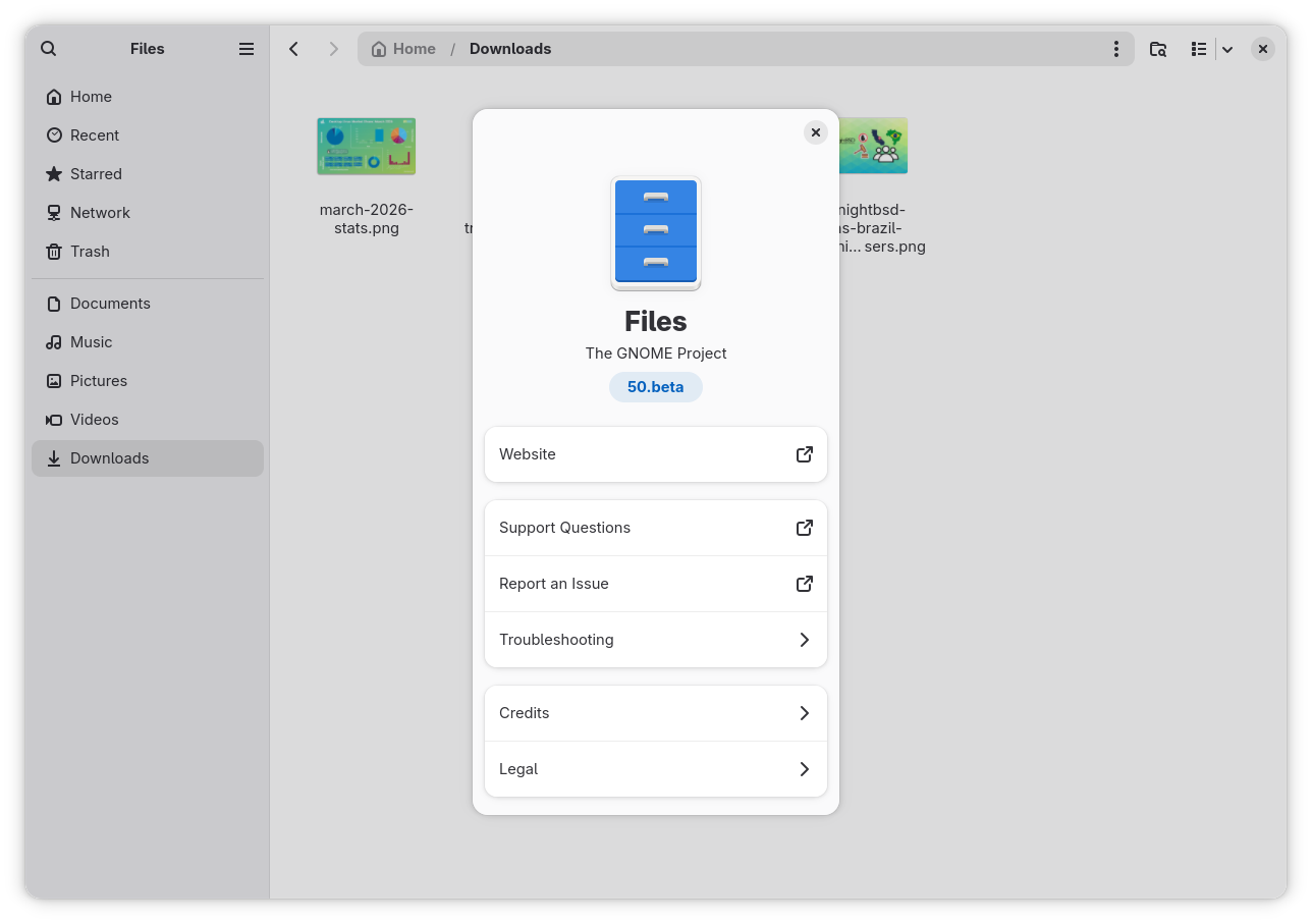 the nautilus (files) file manager app is shown here with the downloads folder open in the background, showing a few image files with their thumbnails, and in the foreground, the about dialog is open, showing the version info for the app, which is 50.beta