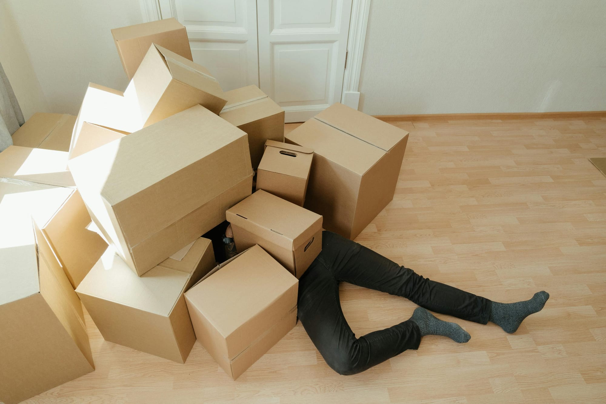 A photo of a person stuck under a bunch of boxes